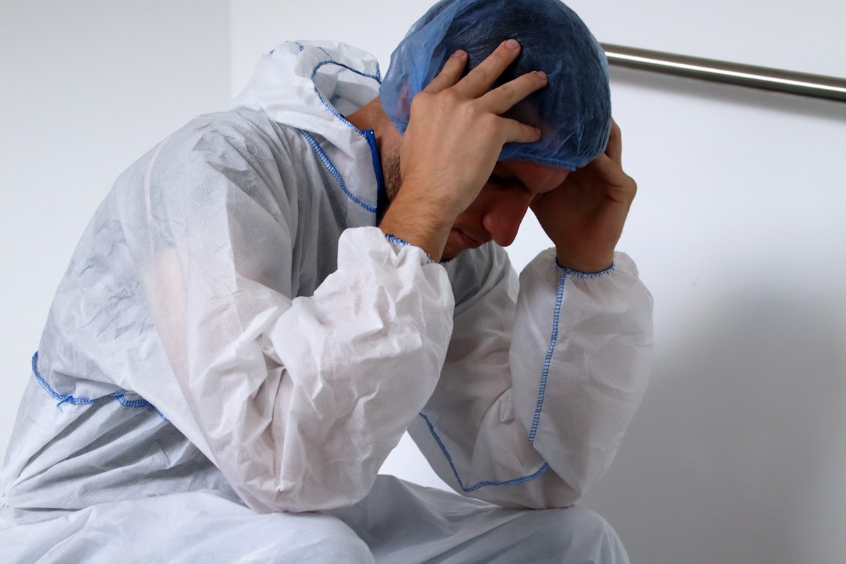 밤늦게까지 스탠드 조명 아래에서 어두운 화면 속 영문 이력서를 수정하며 자신의 강점을 어떻게 표현할지 고심하는 남성 지원자의 뒷모습